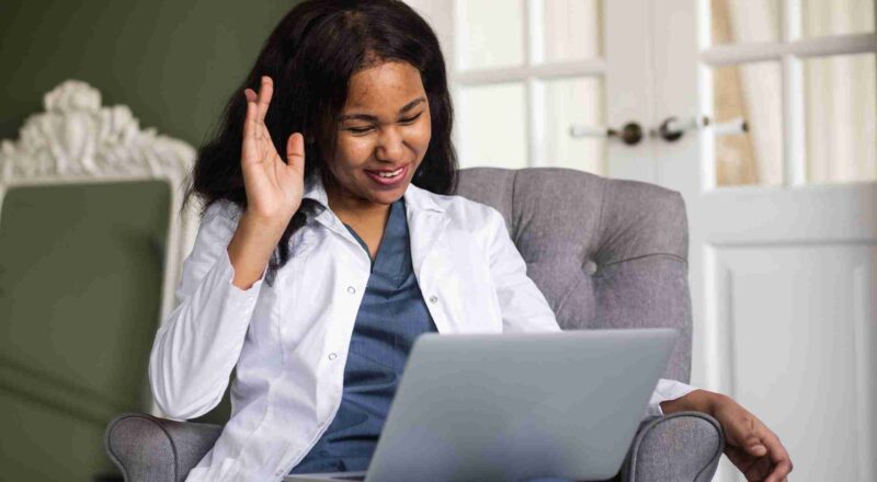 African American female doctor looking at computer