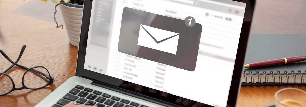 Person typing on the computer with an unread email icon on the screen